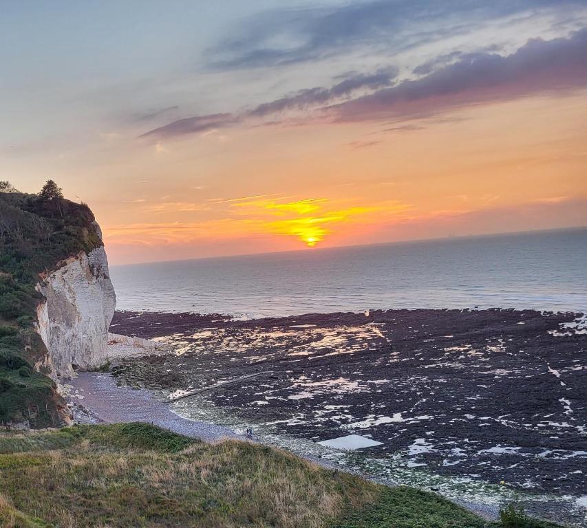 - un coucher de soleil sur l'océan et une plage rocheuse dans l'établissement Le paradis normand, à Saint-Pierre-en-Port