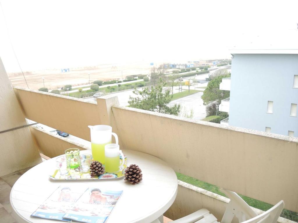 einen Tisch auf einem Balkon mit Stadtblick in der Unterkunft Lovely flat next to Lido dei Pini - Beahost Rentals in Bibione