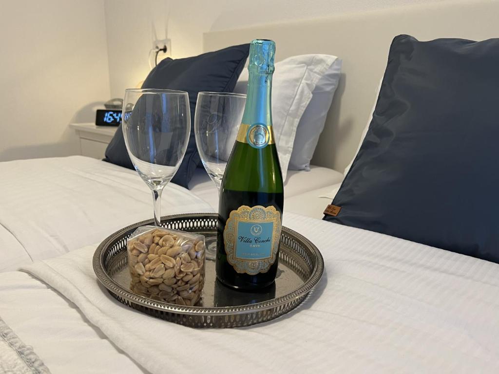 a bottle of wine and glasses on a bed at Le Normandy 5star in Cadzand