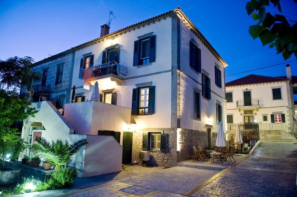 a large white building with lights on at Artemis Traditional Hotel in Myrina