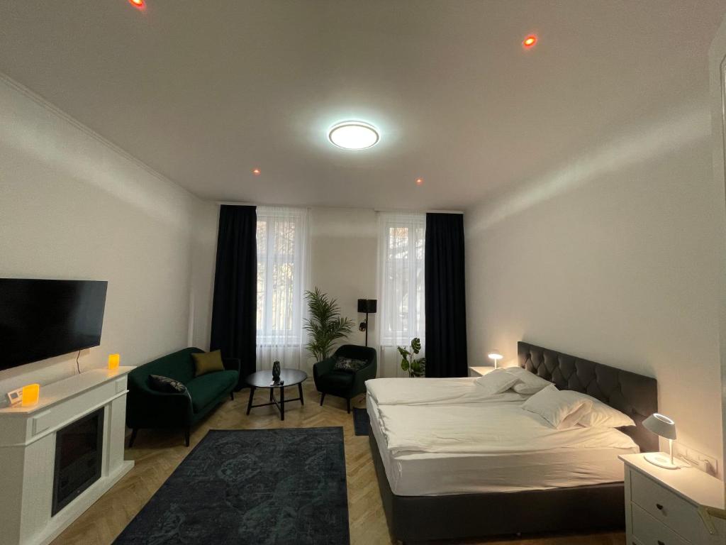 a bedroom with a bed and a living room with a tv at Fullmoon Luxury Apartment in Szeged