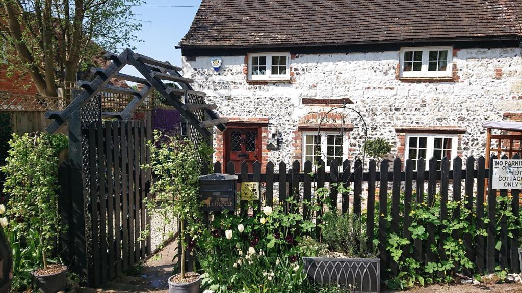 uma cerca de madeira em frente a uma casa de pedra em Charming 17th Century 2-Bed Cottage in Medmenham em Medmenham