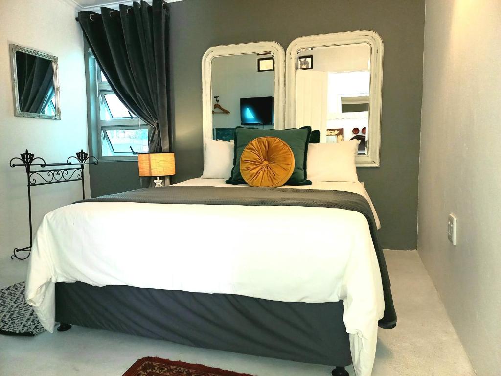 a bedroom with a large bed with a large mirror at Rock Fig Suite - Villa Roc Guesthouse in Salt Rock
