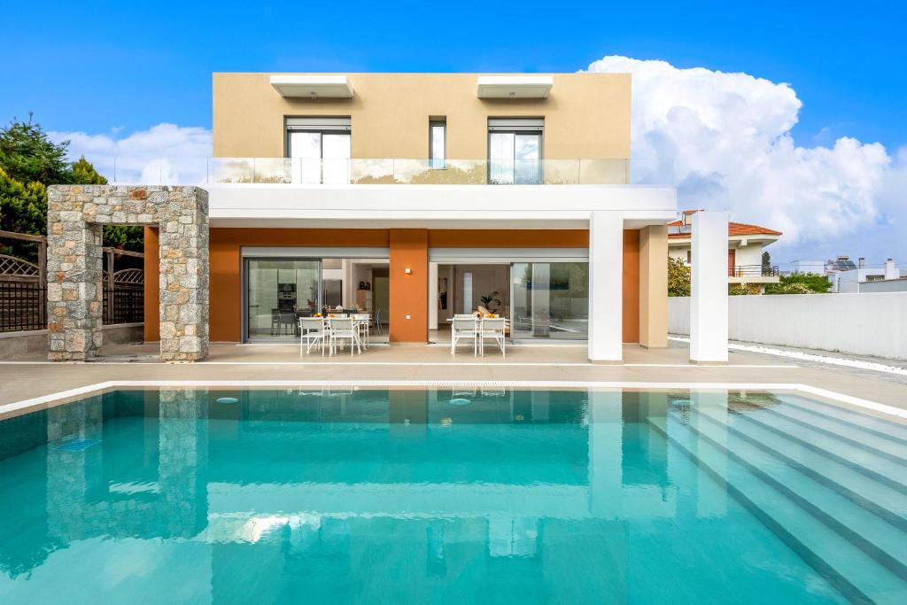 una casa con piscina frente a una casa en Ialyssos Charme Villa, en Ialisos