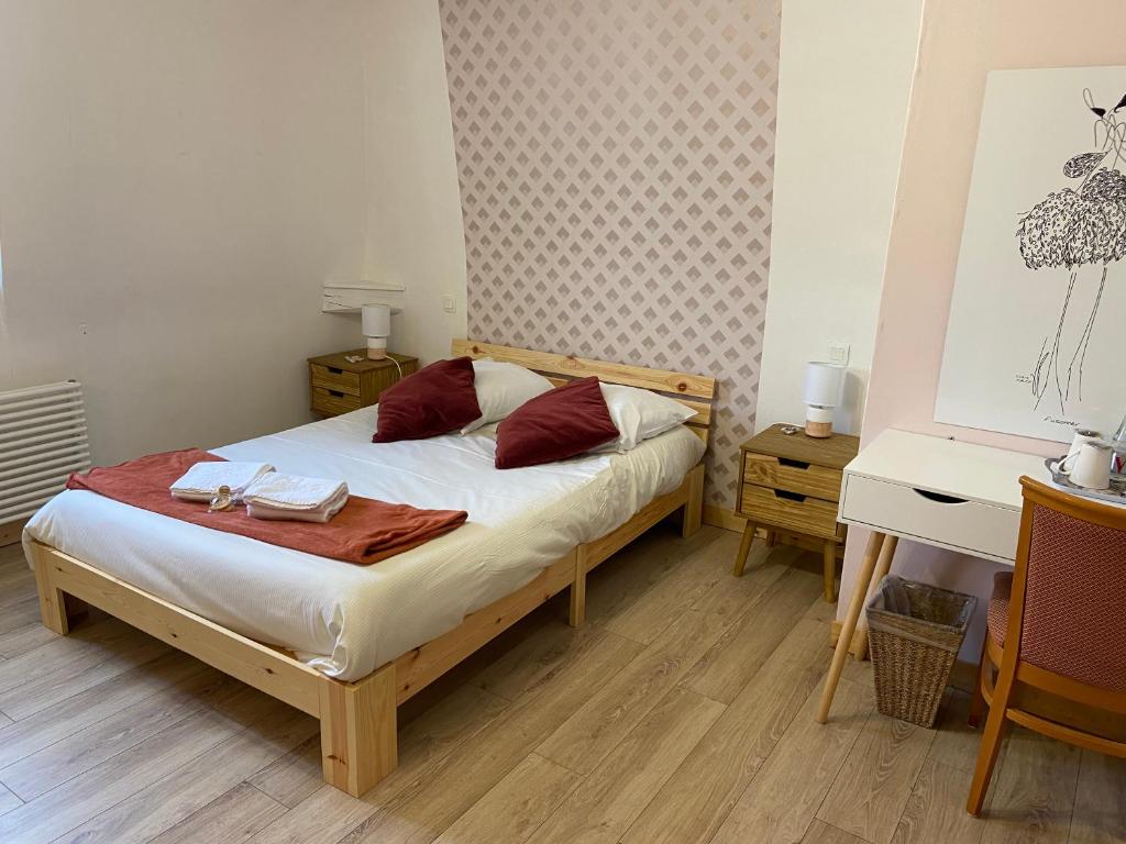 Schlafzimmer mit einem Bett, einem Tisch und einem Schreibtisch in der Unterkunft Hôtel SPA Le Tosny in Épaignes