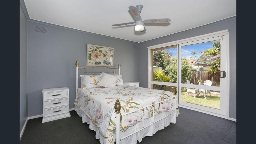 um quarto com uma cama e uma janela em Cosy 4 Bedroom Holiday Home - Melbourne Airport em Greenvale