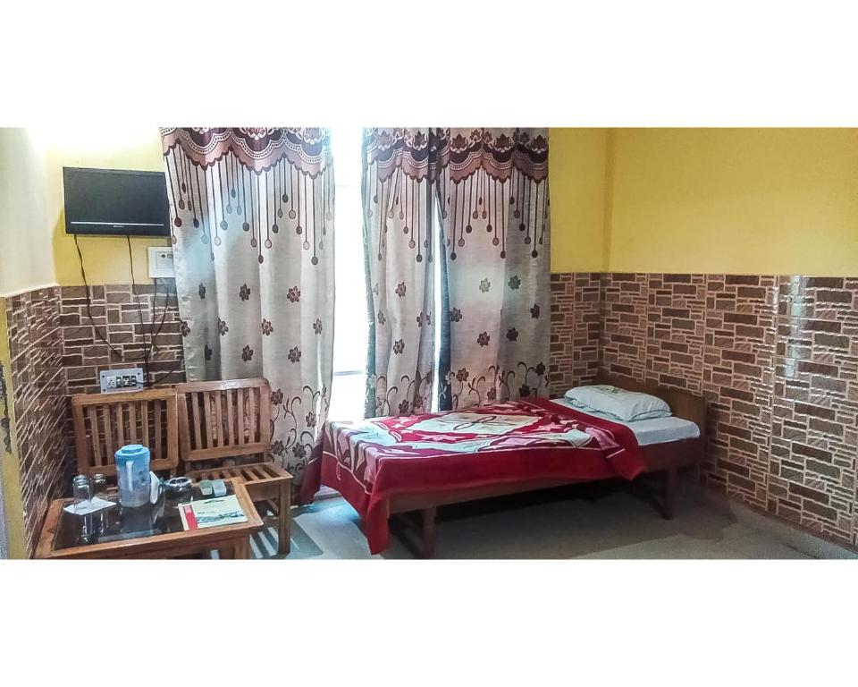 een kamer met een bed en een raam met gordijnen bij Hotel By The Way By WB Inn in Jogindarnagar