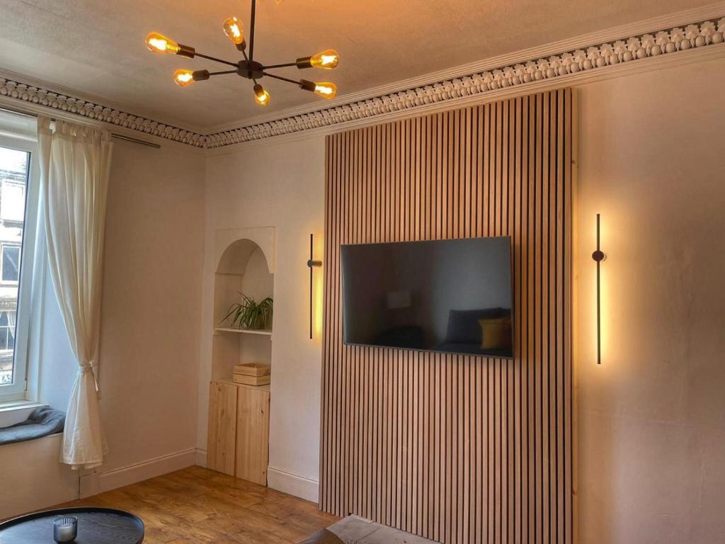 a living room with a television on a wall at 1 Bed Apartment (sleeps 4) on Leith Walk in Edinburgh