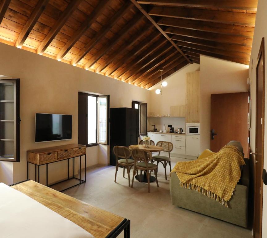 a kitchen and living room with a table and chairs at Casa Señorial del Siglo XVIII in Seville