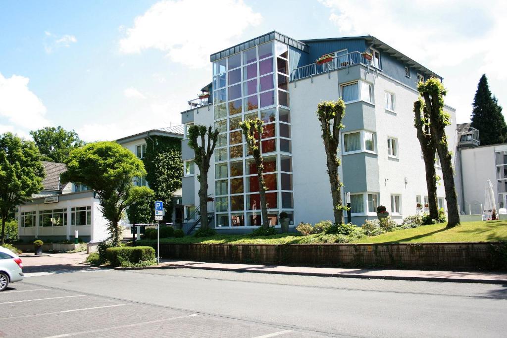 a building with palm trees in front of a street at Kaisergarten Hotel I Restaurant in Neuenrade