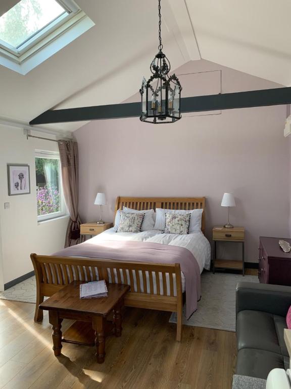 a bedroom with a large bed and a couch at The Snuggery Broadclyst in Exeter