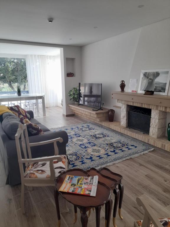 a living room with a couch and a fireplace at Hall 92 Quartos com WC em moradia com piscina A-das-Lebres Loures in Loures