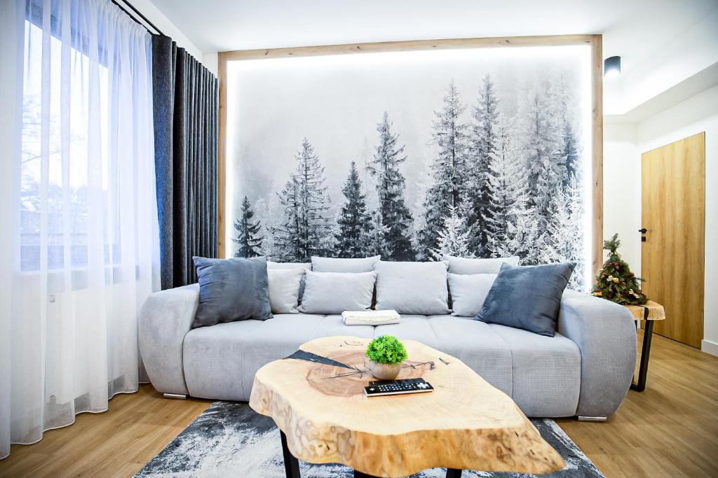 un soggiorno con divano e tavolo di VisitZakopane - Radowid Loft Spa Apartment a Zakopane