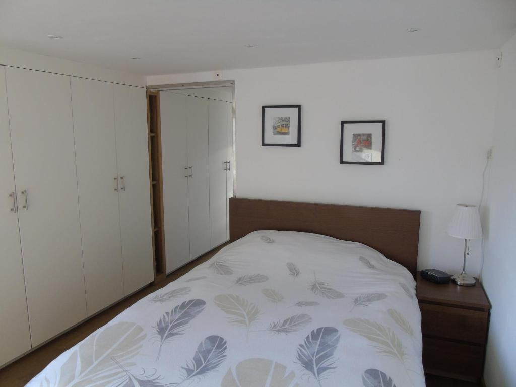 a bedroom with a bed and a white wall at Studio Han Sur Lesse in Han-sur-Lesse