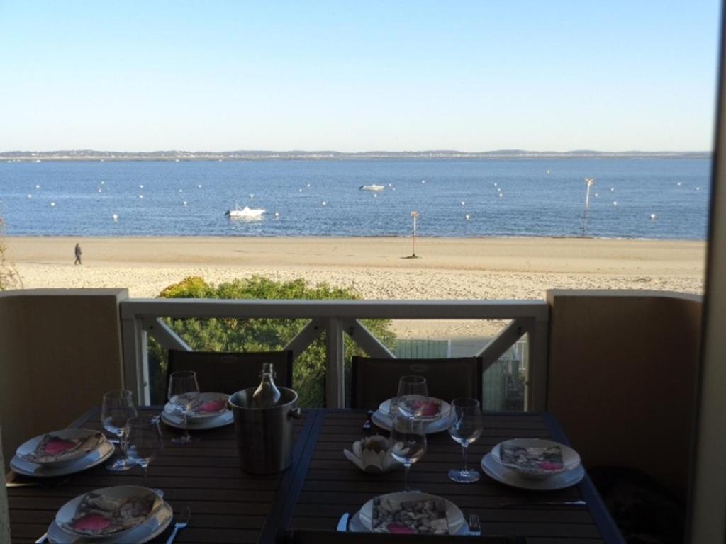 アルカションにあるAppartement Arcachon, 3 pièces, 6 personnes - FR-1-374-24のビーチでの食事とワイングラス付きテーブル