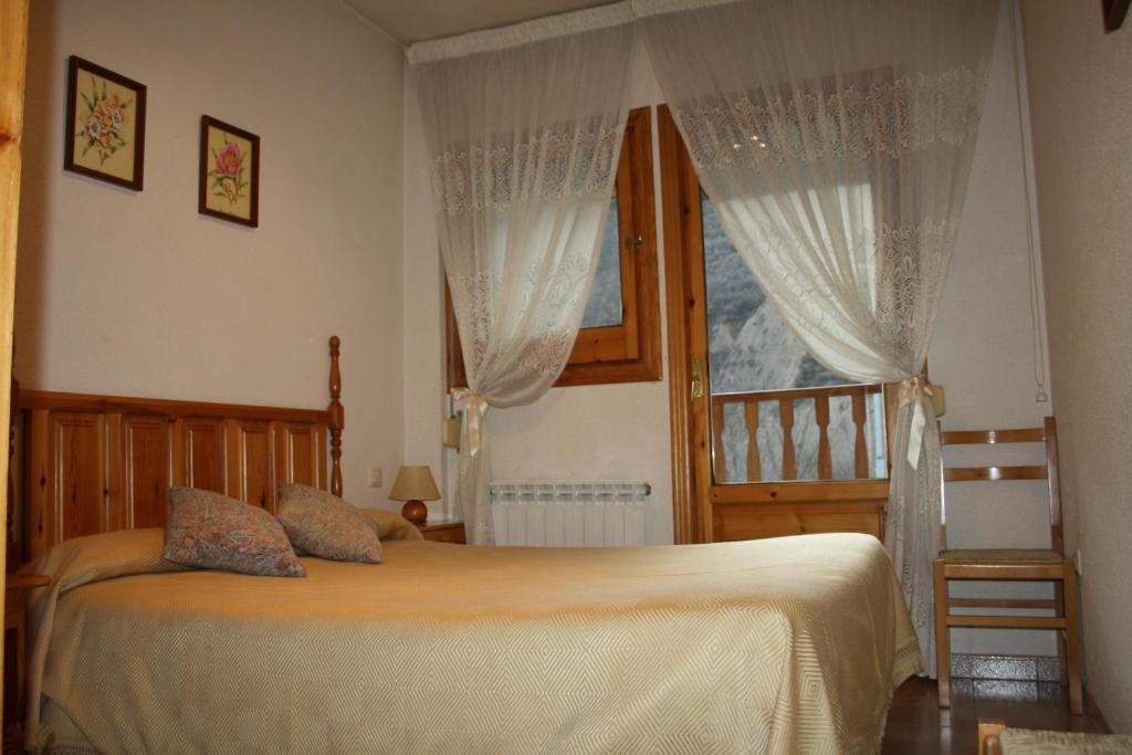 a bedroom with a bed and a window with curtains at Casa Miranda in Campo