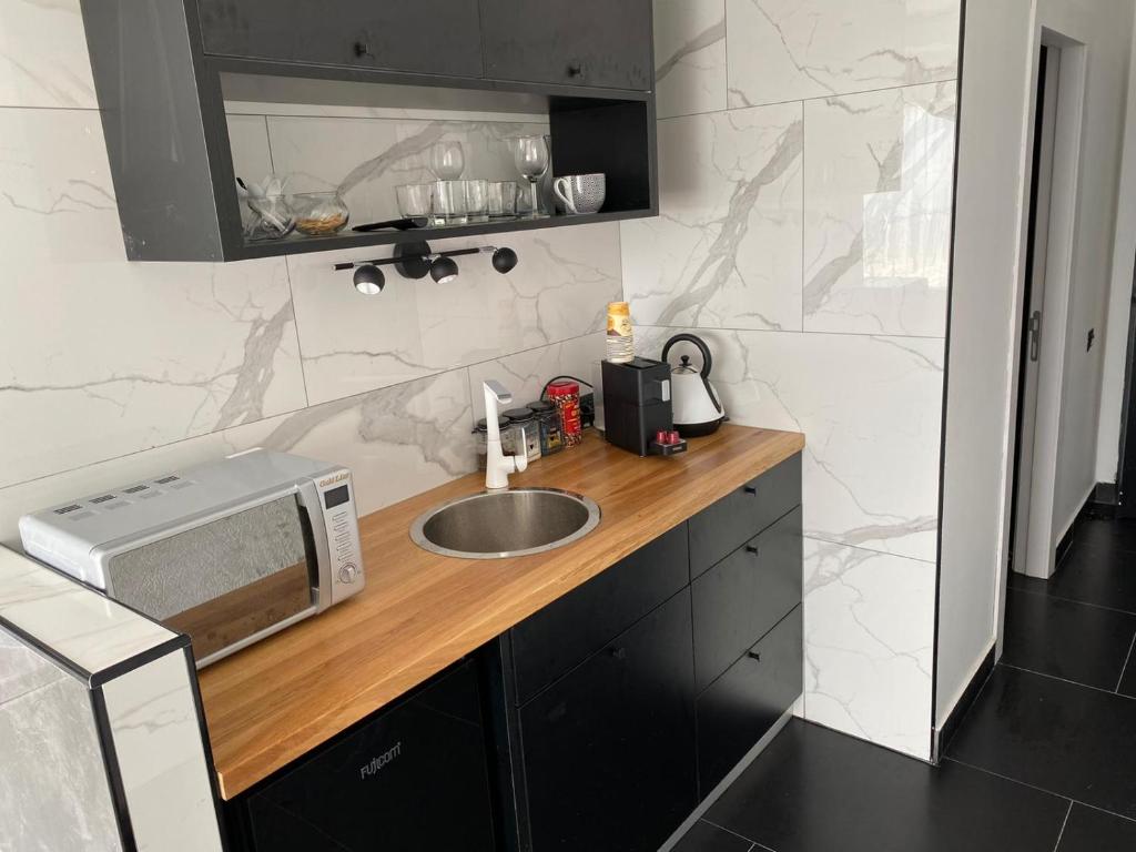 a kitchen with a sink and a microwave on a counter at שקיעה בזכרון in Zikhron Ya'akov