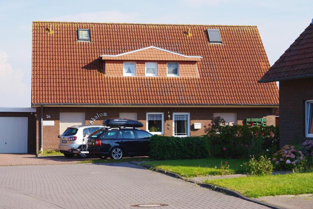 een auto geparkeerd voor een huis met een dak bij Haus Shalom in Neuharlingersiel