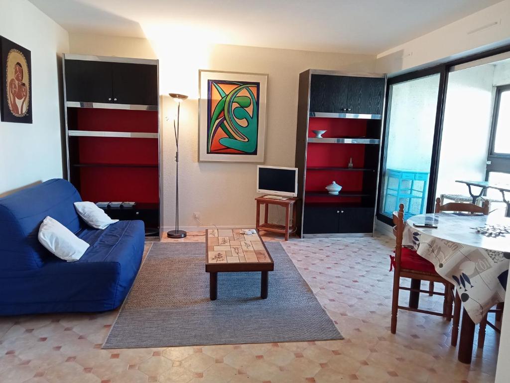 ein Wohnzimmer mit einem blauen Sofa und einem Tisch in der Unterkunft Appartement La Rochelle, 3 pièces, 6 personnes - FR-1-551-1 in La Rochelle