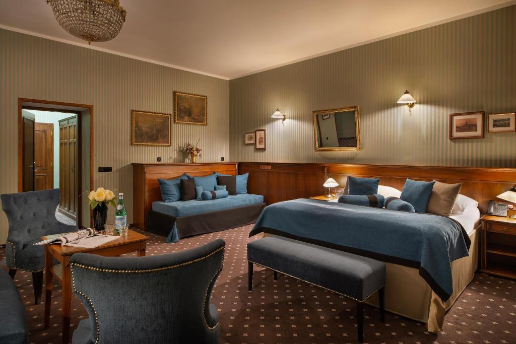 ein Hotelzimmer mit einem Bett und einem Wohnzimmer in der Unterkunft Hotel Morris Premium Collection in Česká Lípa