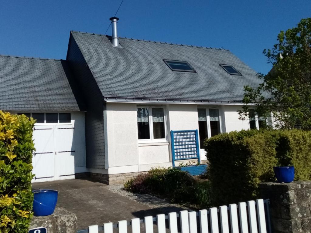 une maison avec un garage blanc et bleu dans l'établissement Maison de vacances à Sarzeau, entre plages et golfe, calme et bien équipée - FR-1-639-27, à Sarzeau