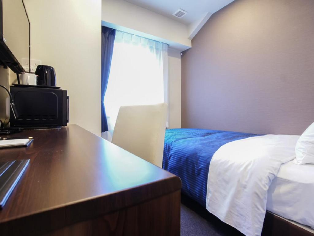 Postel nebo postele na pokoji v ubytování HOTEL LiVEMAX Yokohama Motomachi Ekimae