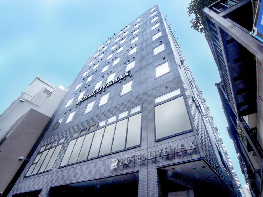 un edificio alto con un cartel en el costado en HOTEL LiVEMAX Yokohama Motomachi Ekimae en Yokohama