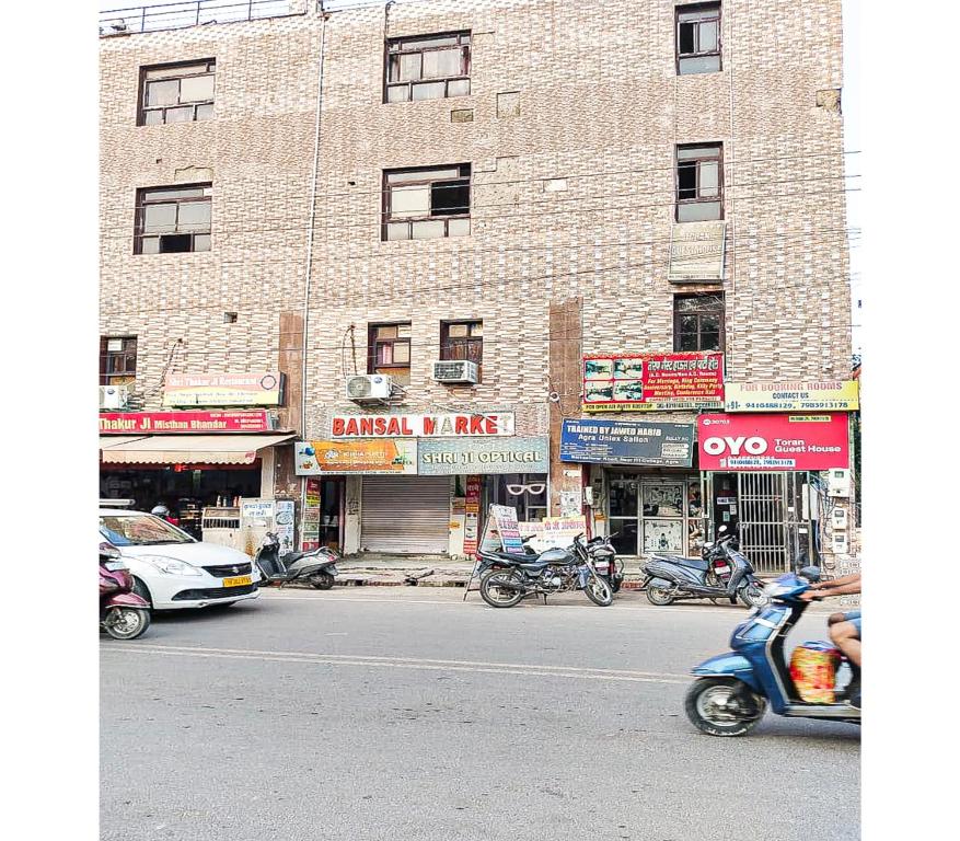 een straat met motorfietsen geparkeerd voor een gebouw bij Toran Guest House By WB Inn in Agra