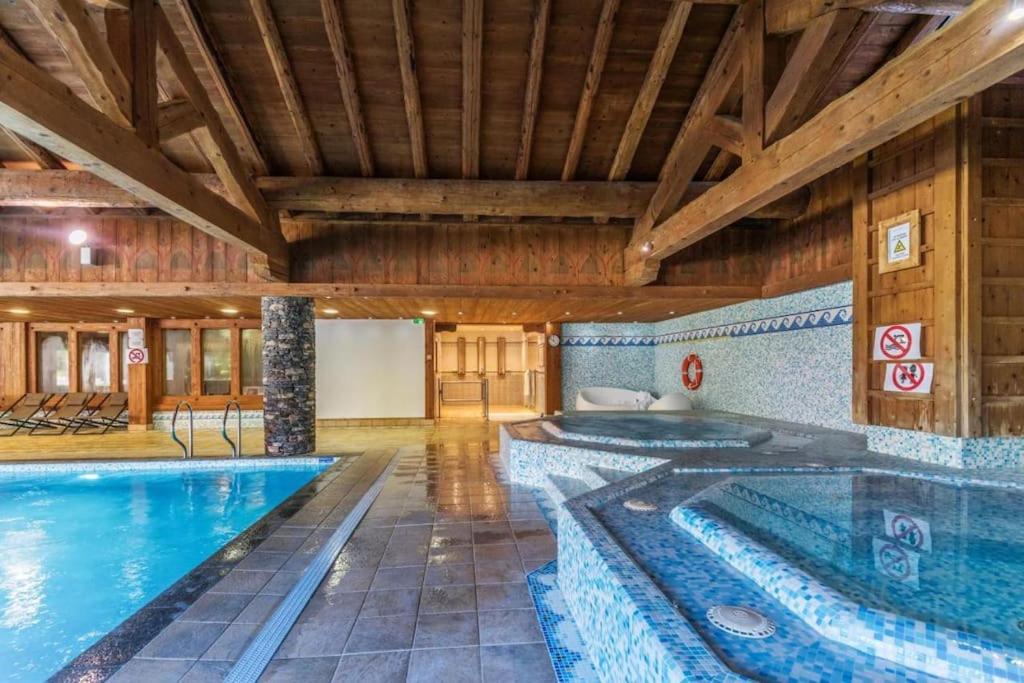 uma piscina interior numa casa com uma grande piscina em SCI Maha em Les Carroz d'Arâches