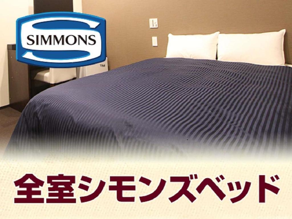 Postel nebo postele na pokoji v ubytování HOTEL LiVEMAX Yokohama Motomachi Ekimae