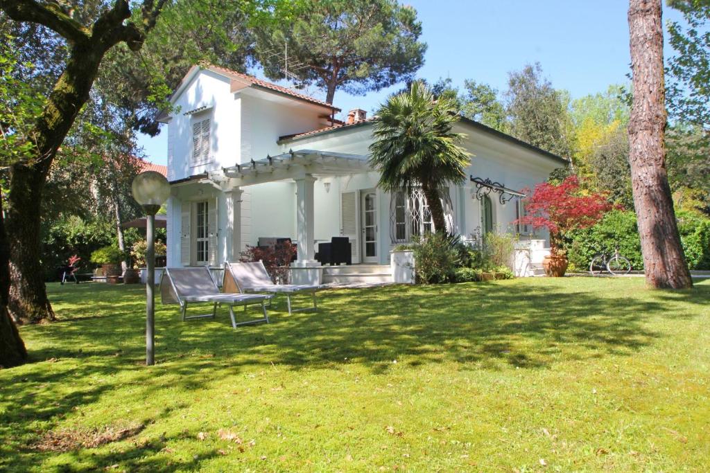 uma casa branca com um banco no quintal em Villa Poveromo em Massa