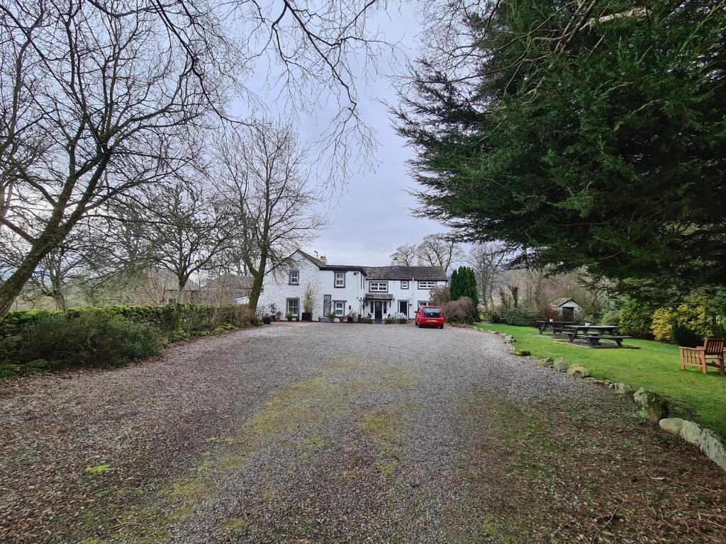 a large white house with a car parked in the driveway at Lane Head Farm Country Guest House in Troutbeck
