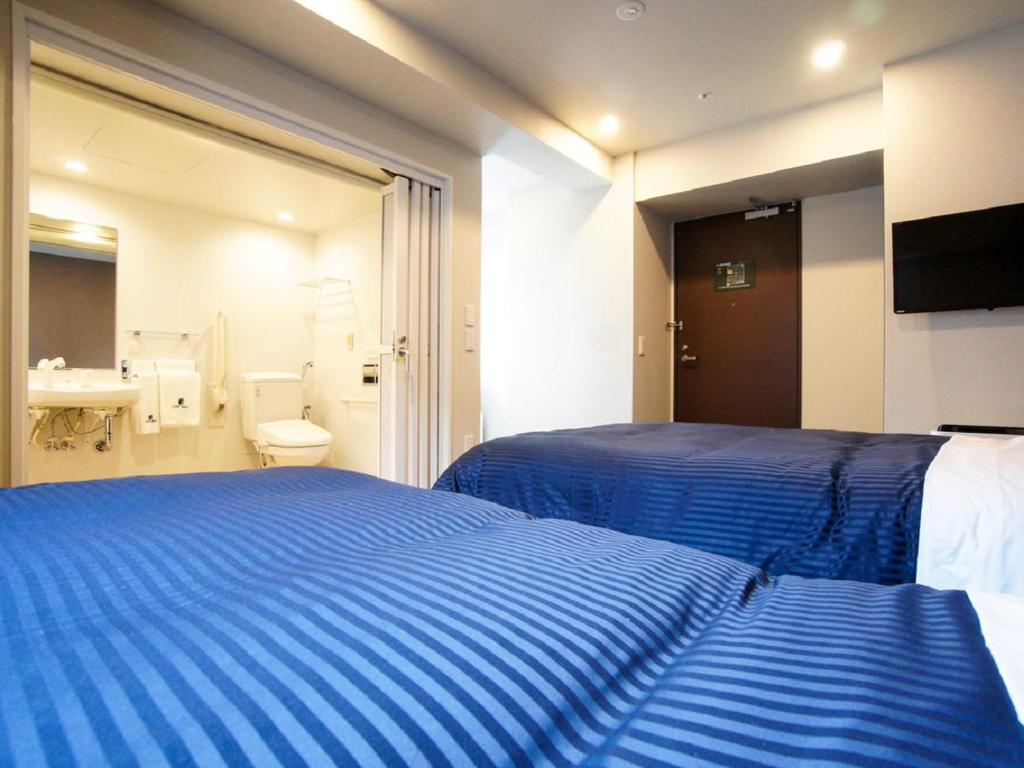 Postel nebo postele na pokoji v ubytování HOTEL LiVEMAX Yokohama Motomachi Ekimae