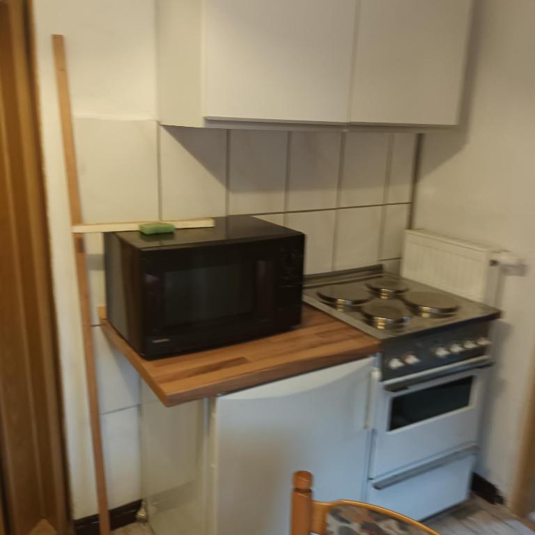 a small kitchen with a microwave and a stove at Bei Rosario in Steinach