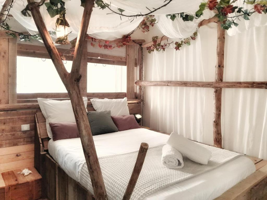 ein Schlafzimmer mit einer Leiter mit Blumen an der Decke in der Unterkunft le Crusoé à l'étang d'Anty - appartement in Saint-Nabord