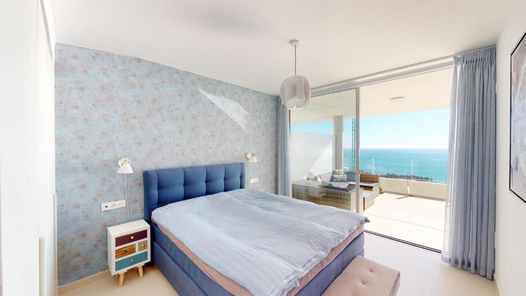 sypialnia z niebieskim łóżkiem i balkonem w obiekcie Stupa Hills VII - Luxury Apartment Casa Susan w mieście Benalmádena