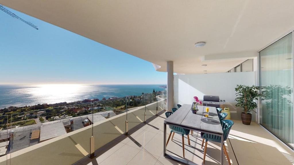 balkon ze stołem i krzesłami oraz widokiem na ocean w obiekcie Stupa Hills VII - Luxury Apartment Casa Susan w mieście Benalmádena