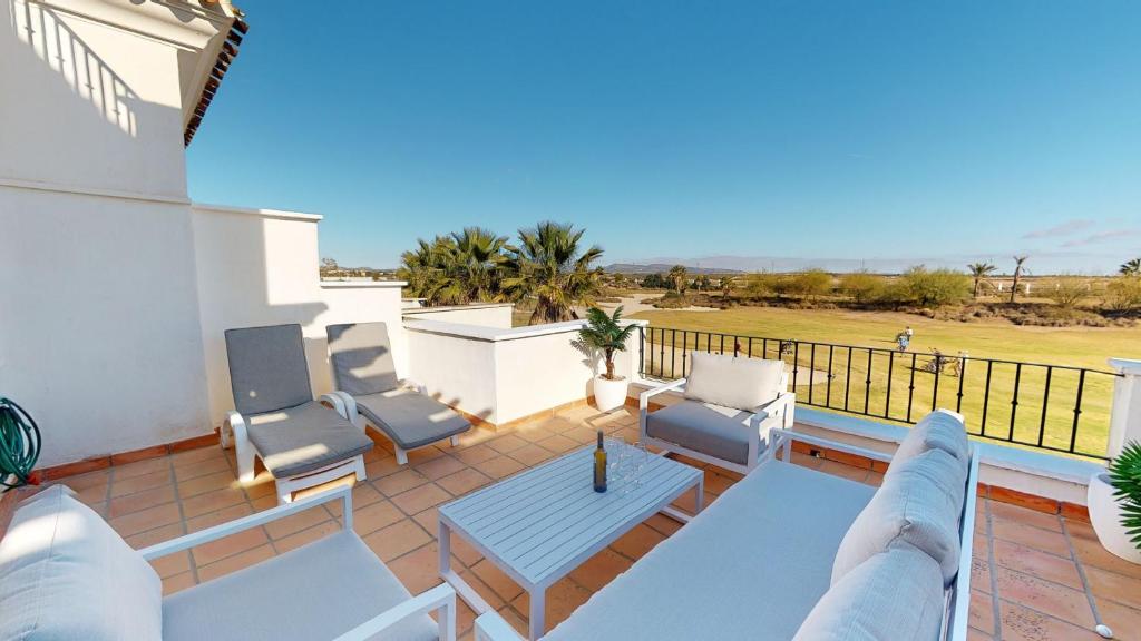 d'une terrasse avec des chaises et une table sur un balcon. dans l'établissement Casa Esturion J-A Murcia Holiday Rentals Property, à Roldán