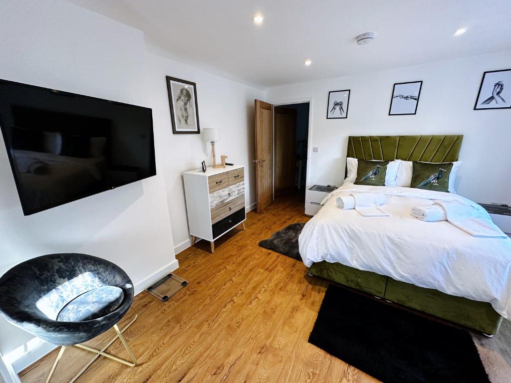 a bedroom with a bed and a flat screen tv at 2 Southwell Road - Luxurious City Centre Apartments in Norwich