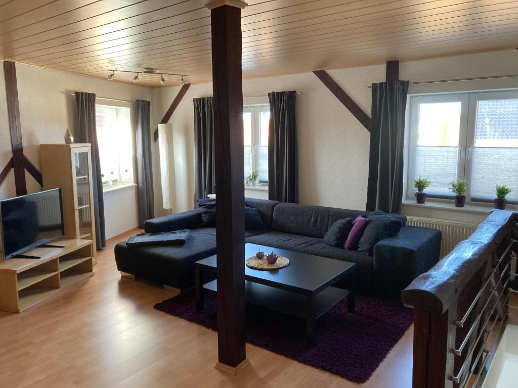 a living room with a blue couch and a tv at Ferienwohnung-Relax-Schleesen 