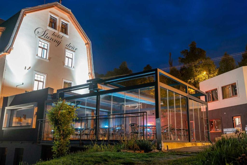 a large building with a glass facade at night at Hotel Slunný Dvůr in Jeseník