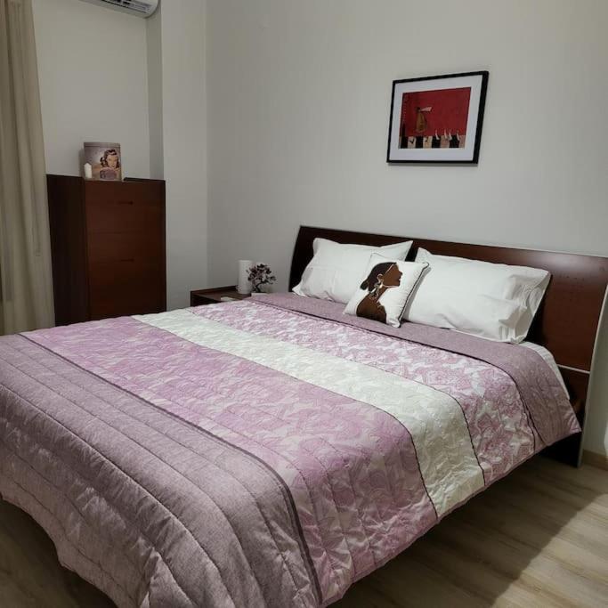 a bedroom with a large bed with a purple blanket at BEAUTIFUL APARTMENT IN VERIA in Veria