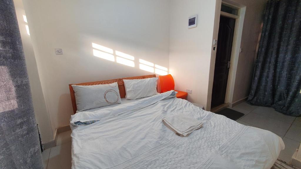 sypialnia z łóżkiem z białą pościelą i dwoma pierścieniami w obiekcie Ruth's Haven w mieście Kidono