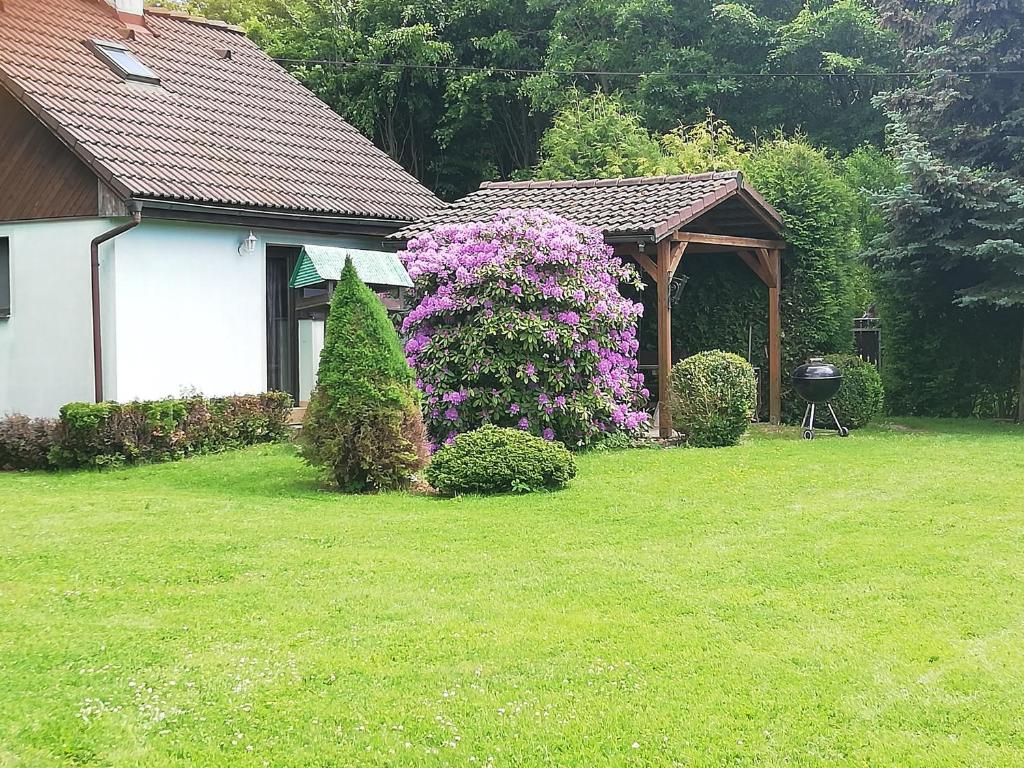 um jardim com um gazebo e flores roxas em Chaty v Českém ráji u Prachovských skal Chata pro 4 a pro až 7 osob - v soukromí em Holín