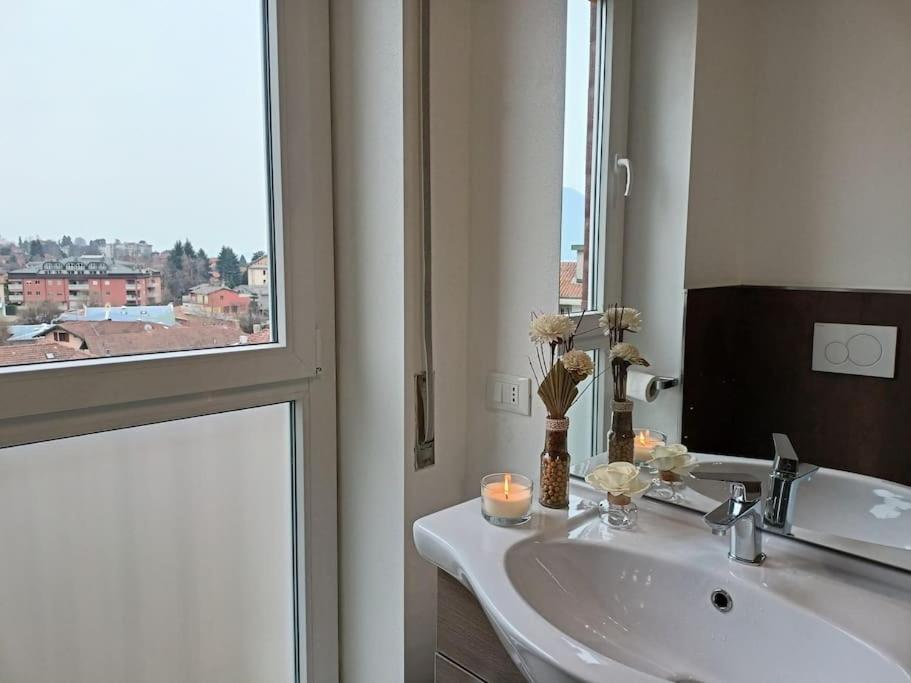 un bagno con lavandino, specchio e finestra di La perla del lago a Verbania