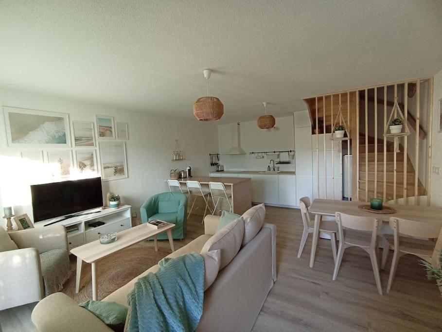 salon z kanapą i stołem w obiekcie Le Petit Eden des Dunes w mieście Seignosse