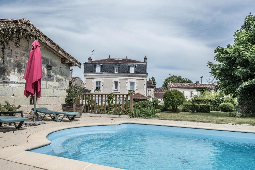 a swimming pool in front of a house at Les Tuileries de Chanteloup in La Roche-Chalais