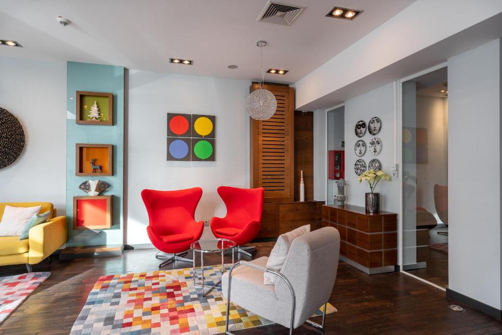 a living room with red chairs and a couch at numa I Bona Rooms & Apartments in Bonn