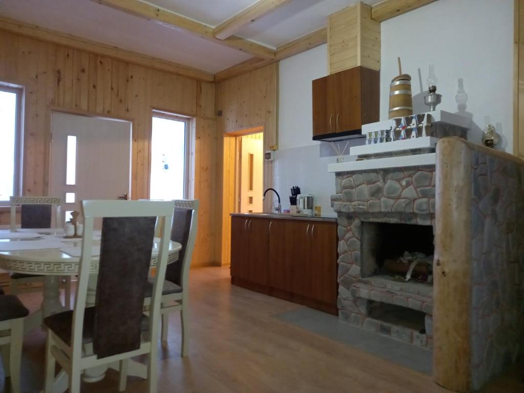 a kitchen and dining room with a stone fireplace at У бабусі in Bursuchna