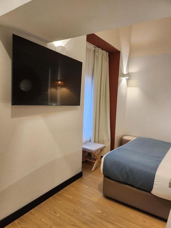a hotel room with a bed and a flat screen tv at Soho Boutique Cádiz in Cádiz